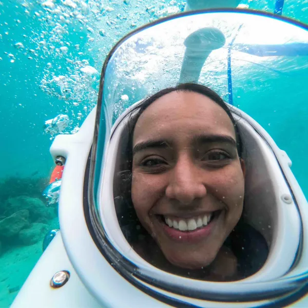 a smiling woman in front of a mirror posing for the camera