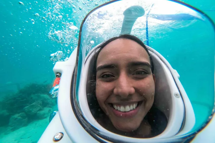 a smiling woman in front of a mirror posing for the camera