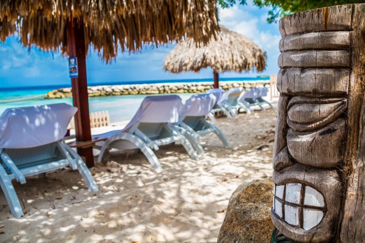 a group of lawn chairs sitting on top of a sandy beach