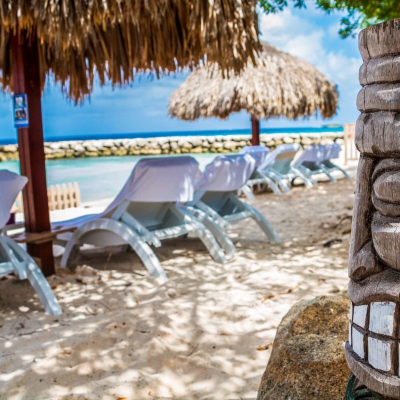 a group of lawn chairs sitting on top of a sandy beach