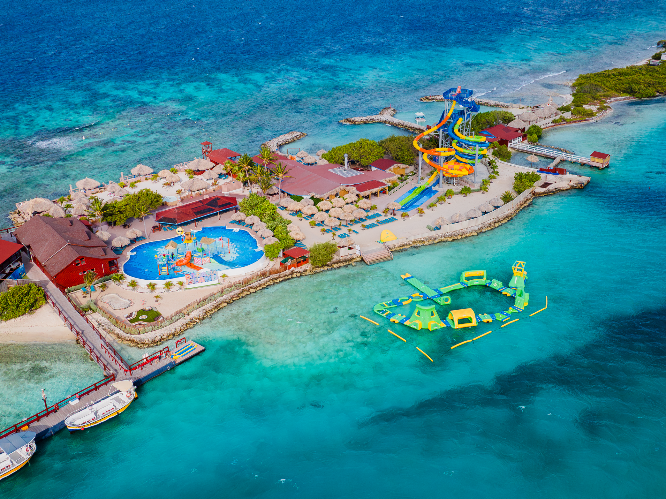 Aerial view of a tropical island resort with pools and water slides.