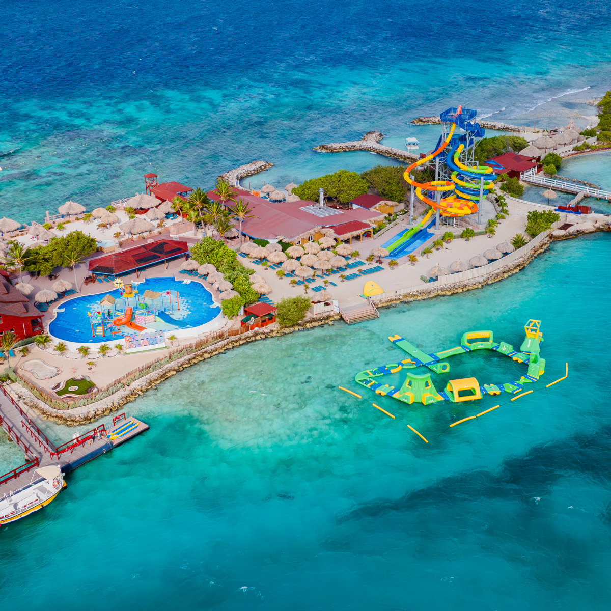 Aerial view of a tropical island resort with pools and water slides.